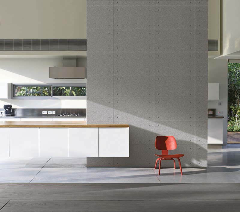 Red moulded chair against concrete wall in house designed by Weinstein Vaadia Architects, Hofit, Israel., Architects: Architects: Weinstein Vaadia Architects